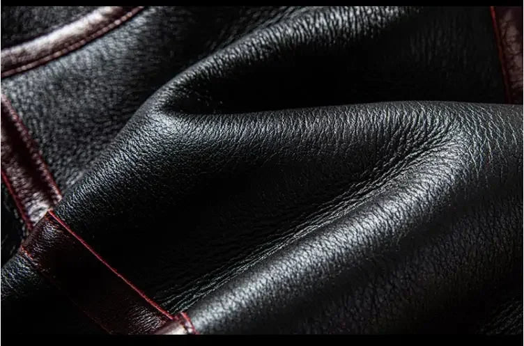 Close-up of black leather texture with red stitching