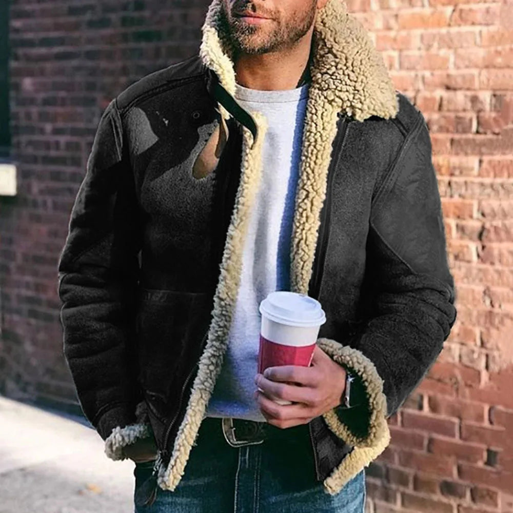 Man wearing a black shearling jacket holding a red coffee cup against a brick wall.